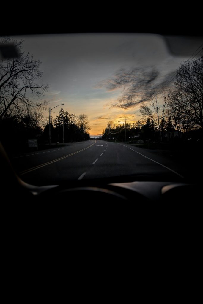 es wurde aus einem Auto heraus fotografiert sodass man die Mittelkonsole und eine Teerstraße sieht. Draußen ist es recht dunkel geht gerade die Sonne auf oder unter. Es symbolisiert den neuen Beitrag für die Pendlerpauschale.